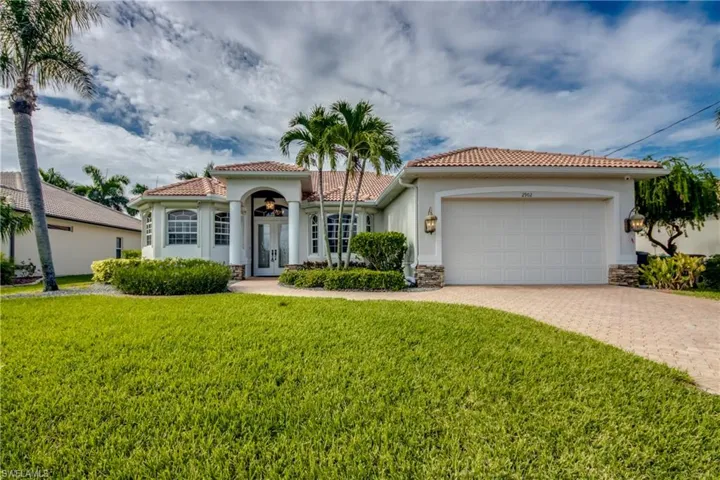 Mediterranean / spanish home featuring a garage and a front yard