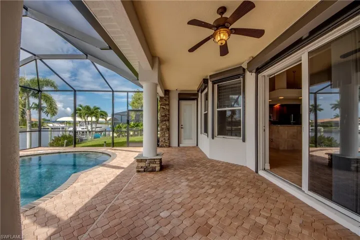 View of pool with ceiling fan, a patio area, and a lanai