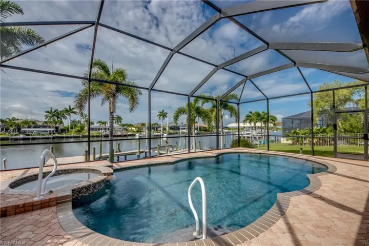 View of pool featuring an in ground hot tub, a patio, and glass enclosure