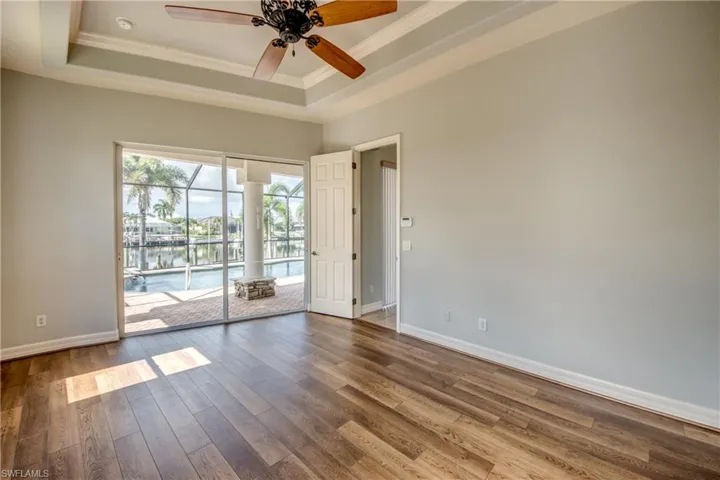 Spare room featuring ceiling fan, hardwood / wood-style floors, and a tray ceiling