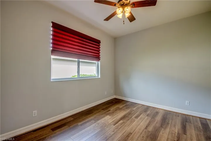 Unfurnished room with ceiling fan and hardwood / wood-style floors