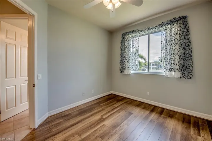 Empty room featuring ceiling fan and hardwood / wood-style flooring