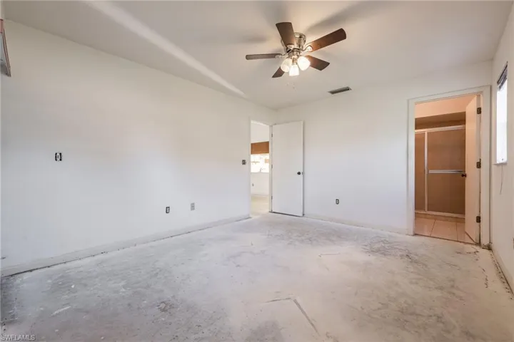 Room featuring a ceiling fan with light fixture, multiple electrical outlets, and neutral white walls