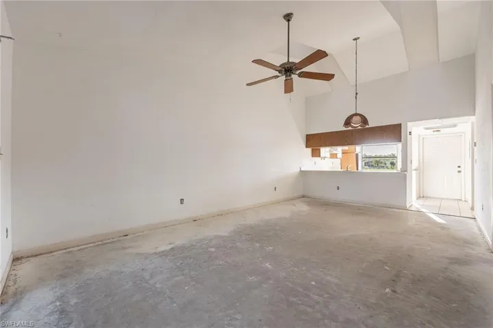 Spacious interior featuring a vaulted ceiling and concrete flooring