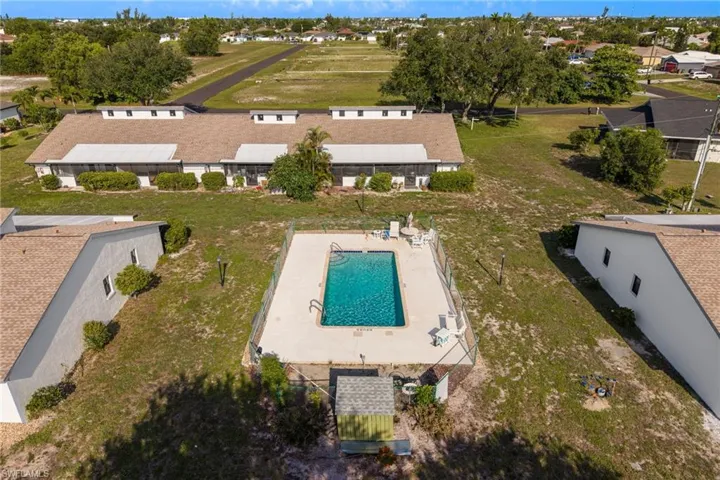 In-ground swimming pool with surrounding concrete deck and perimeter fencing