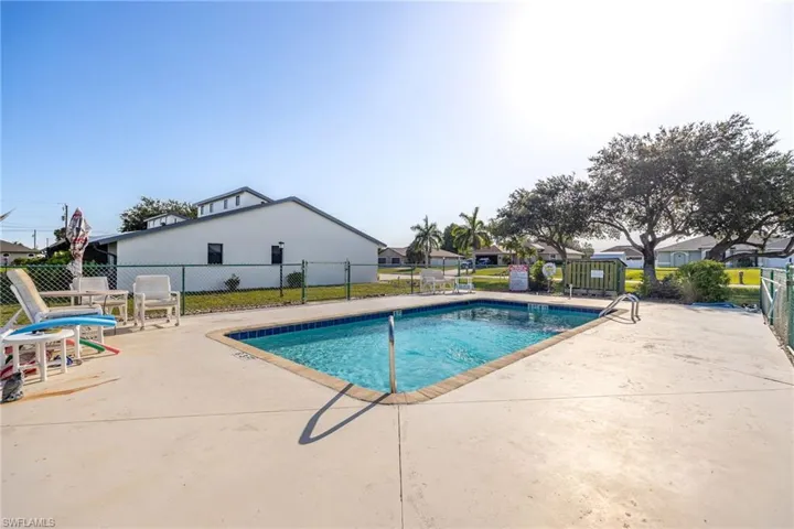 Rectangular inground swimming pool with a surrounding concrete patio