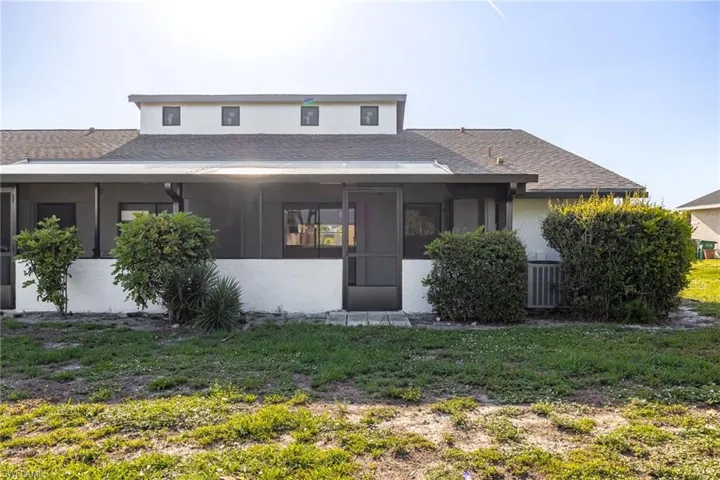 Rear exterior featuring a screened patio and stucco finish