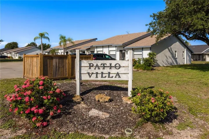 "Patio Villa" signage surrounded by flowering shrubs and bark mulch