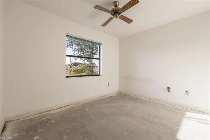 Spacious interior featuring a window with integrated blinds and a ceiling fan