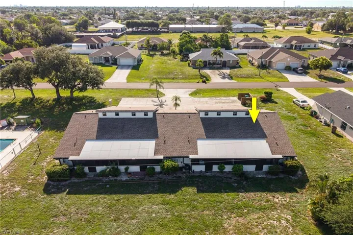 Townhome style property featuring a shingle roof, screened patio, and a communal swimming pool
