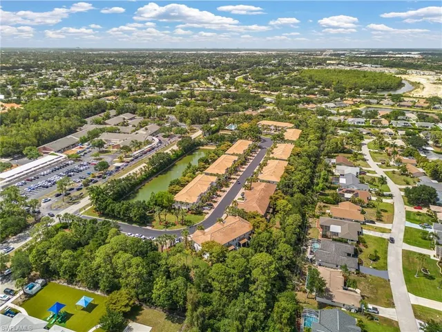 Expansive aerial perspective showcasing a residential community with a central pond
