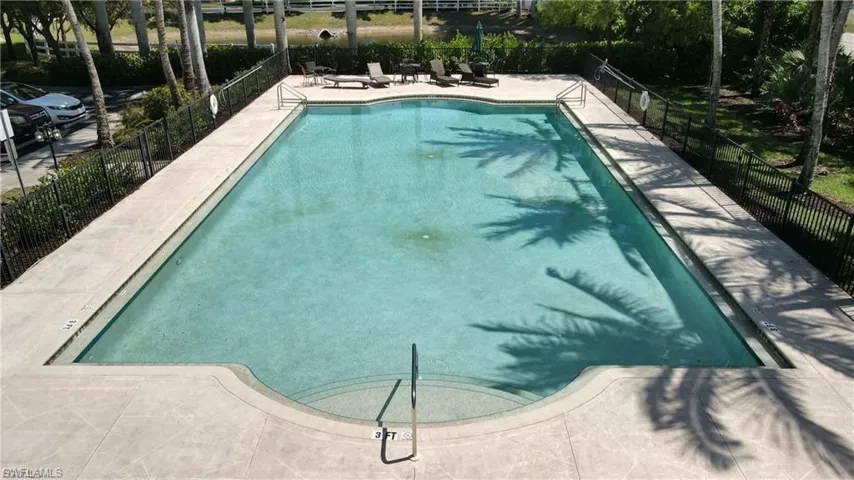 Rectangular swimming pool with integrated steps, surrounded by a light-colored concrete deck