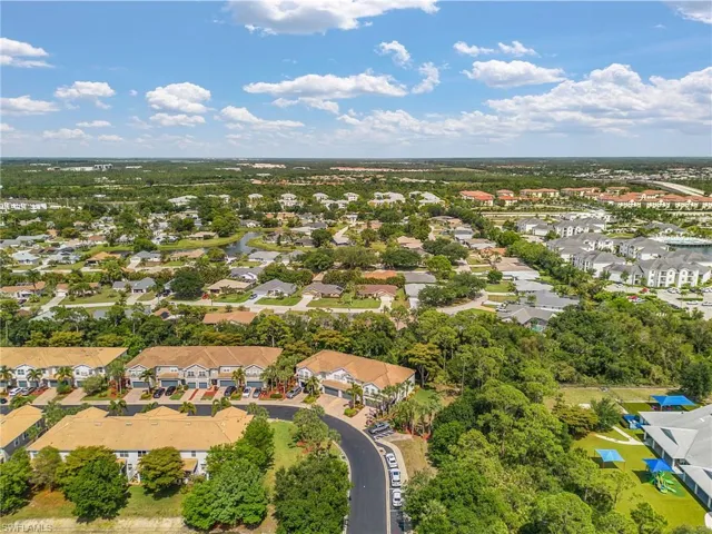 Aerial perspective showcasing a residential area with diverse architectural styles, including multi-story structures and single-family homes