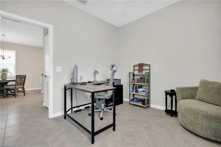 Office with baseboards, a notable chandelier, and light tile patterned floors