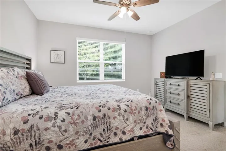Bedroom featuring light colored carpet and ceiling fan