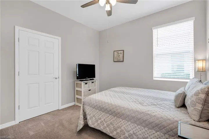 Carpeted bedroom featuring baseboards and a ceiling fan