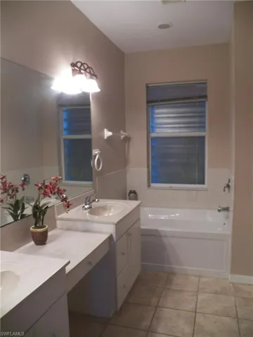 Bathroom featuring double sink vanity and tub
