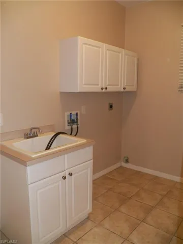 Laundry area with hookup for a washing machine, electric dryer hookup, cabinets,