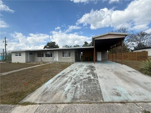 Single story home featuring a carport and driveway
