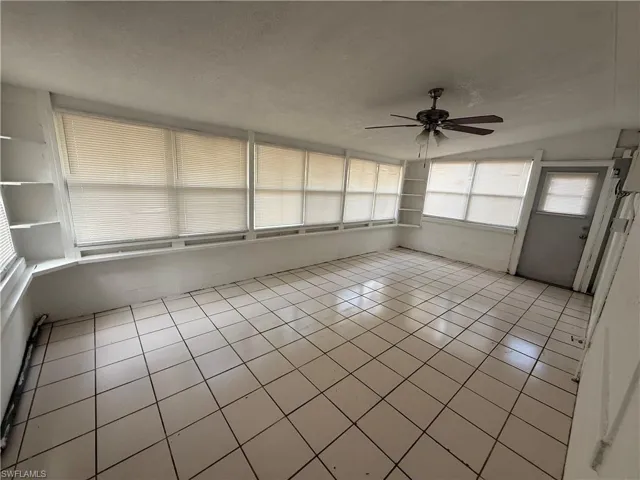 Unfurnished sunroom featuring vaulted ceiling