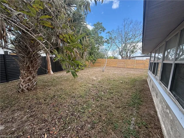 Fenced backyard with a sunroom