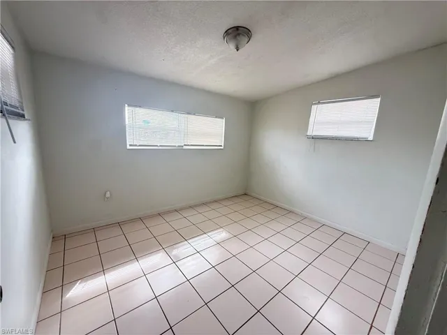 Spare room featuring light tile patterned floors and baseboards