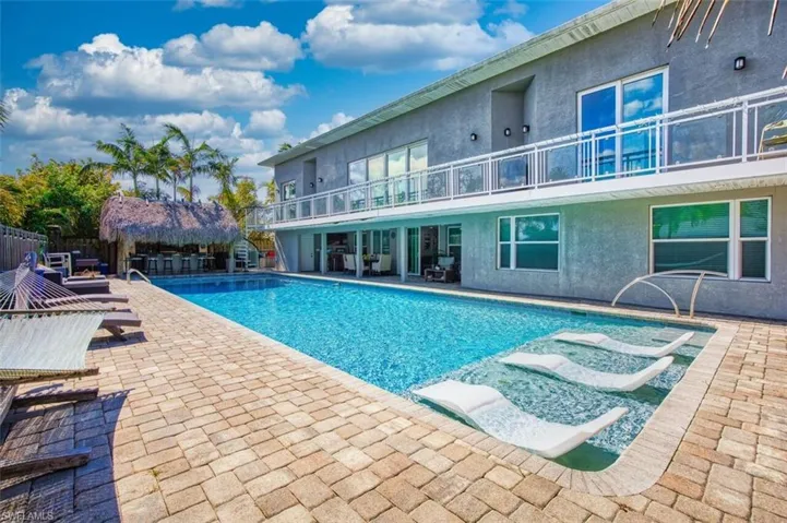 View of pool featuring patio surround and a balcony