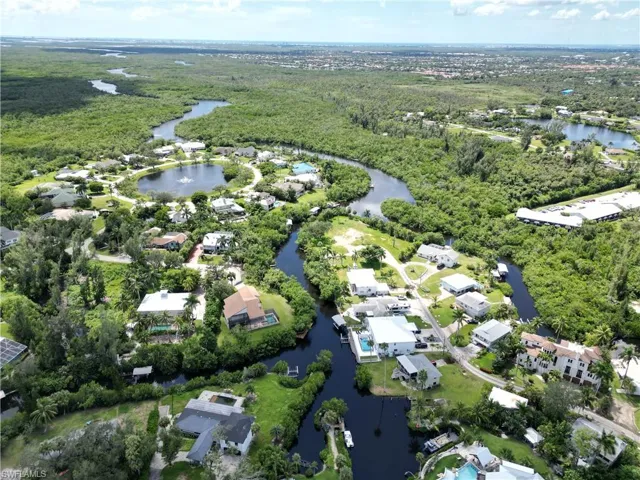 Aerial view of property's location with a large body of water and nearby suburban area