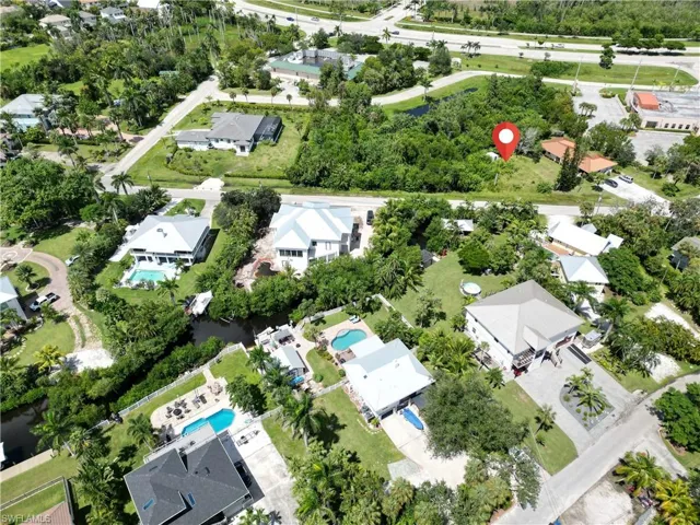 Aerial overview of property's location featuring nearby suburban area and a pool area