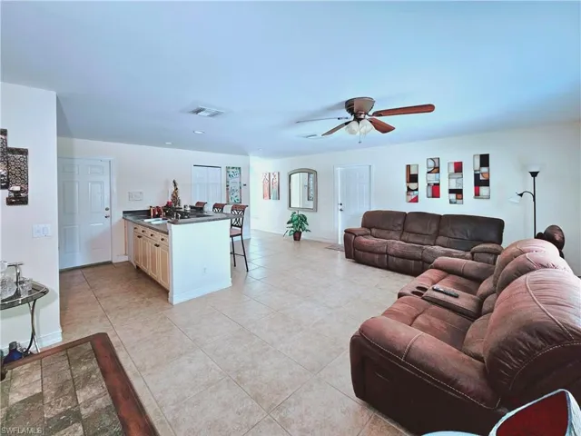 Living area featuring a ceiling fan, light tile patterned floors, and recessed lighting