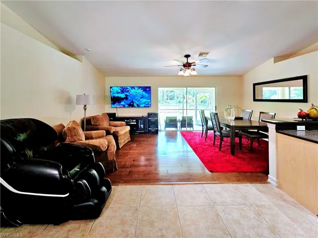 Living area featuring a ceiling fan, vaulted ceiling, and tile patterned floors