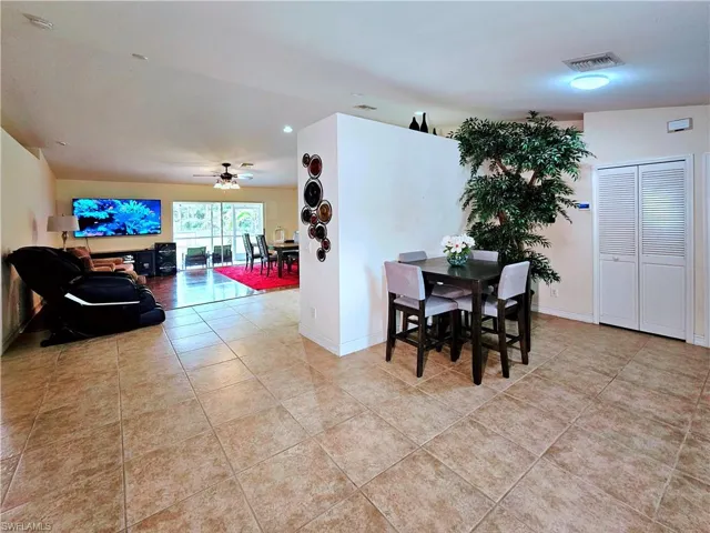 Tiled dining space featuring ceiling fan and baseboards