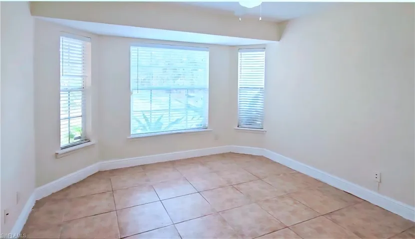 Empty room with healthy amount of natural light and light tile patterned flooring