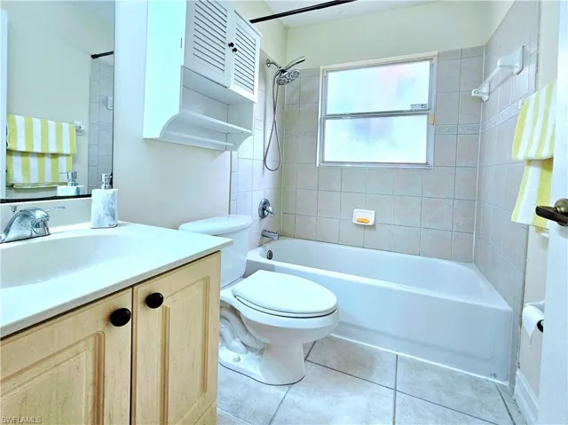 Full bath featuring vanity, bathing tub / shower combination, and tile patterned flooring