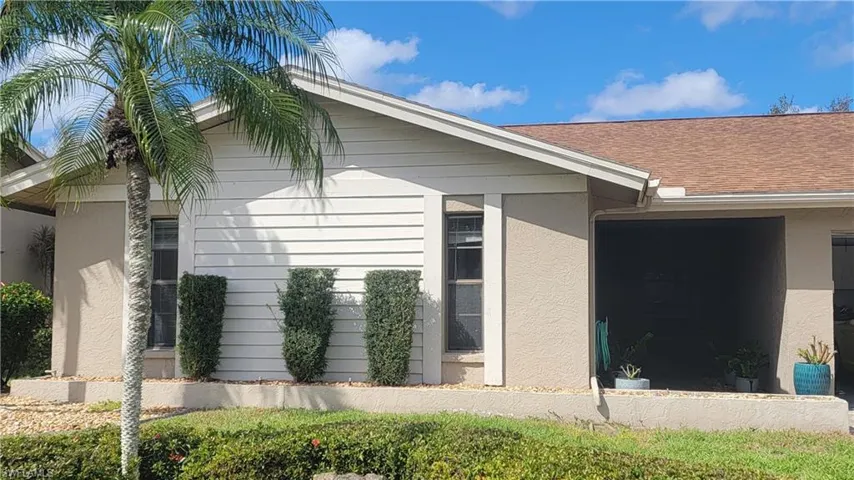 View of property exterior with a shingled roof and stucco siding