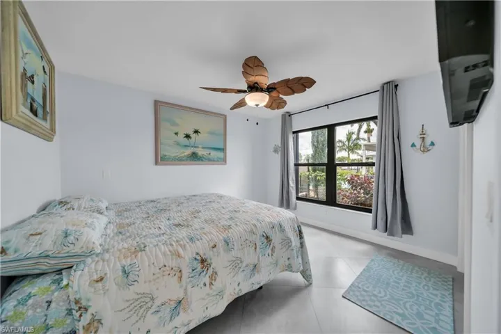 Bedroom with a ceiling fan and light tile patterned flooring