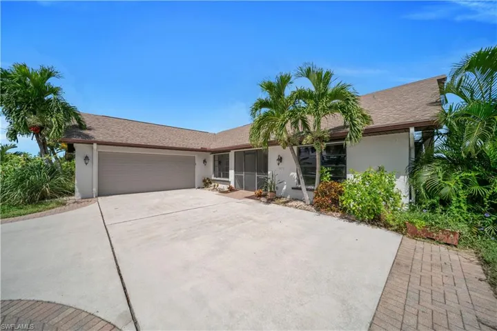 Ranch-style house featuring stucco siding, an attached garage, driveway, a shingled roof, and a sunroom