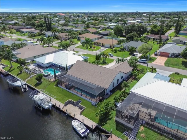 Drone / aerial view of a nearby body of water and a pool area
