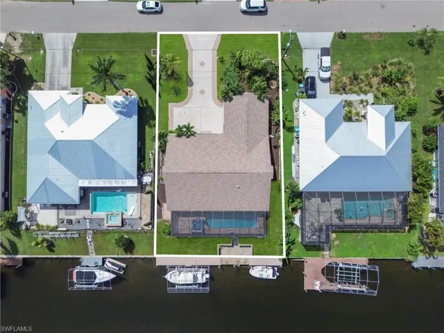 Aerial view of property and surrounding area featuring property boundaries highlighted and a pool