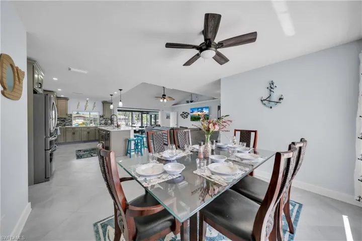 Dining space with a ceiling fan and light tile patterned floors