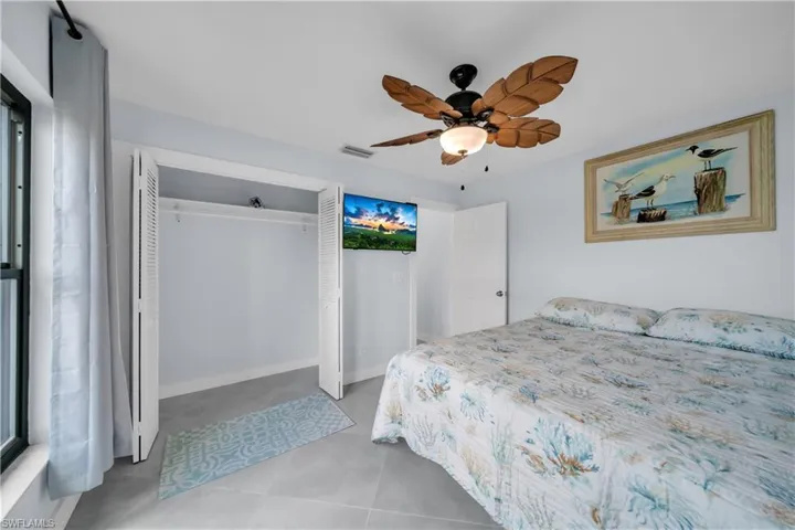 Bedroom featuring ceiling fan, a closet, and light tile patterned floors