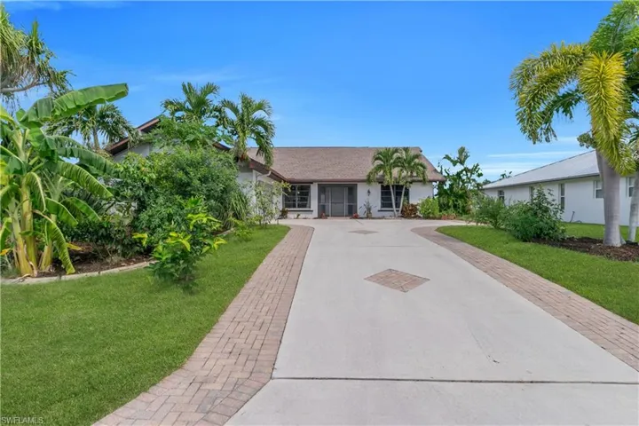 Ranch-style home with decorative driveway, a front lawn, and roof with shingles