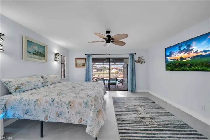 Bedroom featuring access to exterior, ceiling fan, and tile patterned flooring