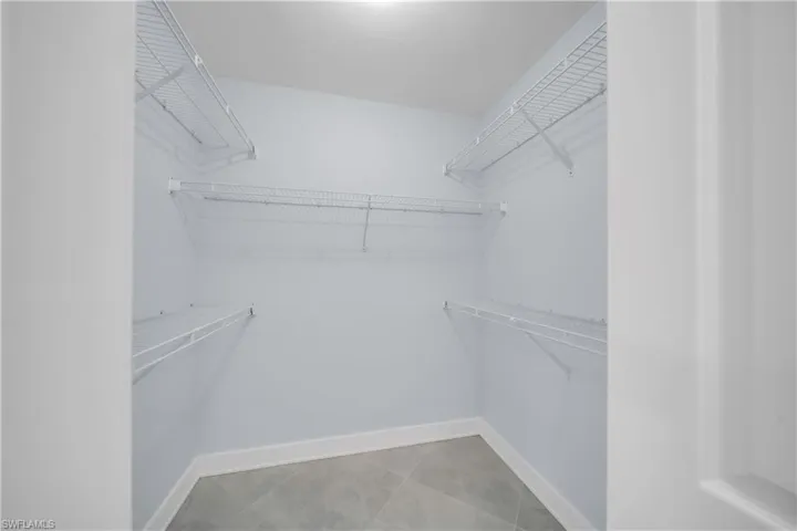 Spacious closet with light tile patterned floors