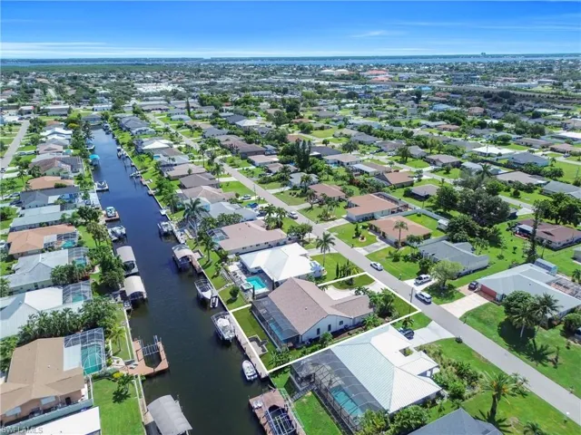 Aerial view of property's location with a nearby body of water and nearby suburban area
