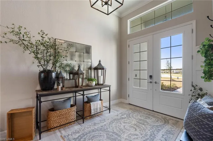 Entrance foyer featuring crown molding, wood-type flooring, and french doors