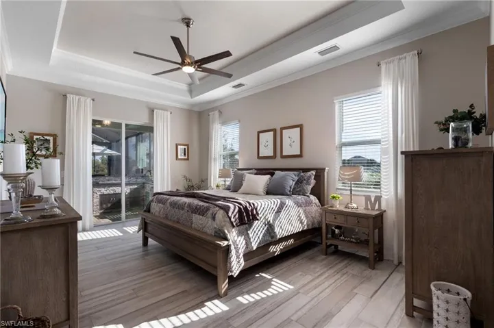 Primary bedroom featuring crown molding, a tray ceiling