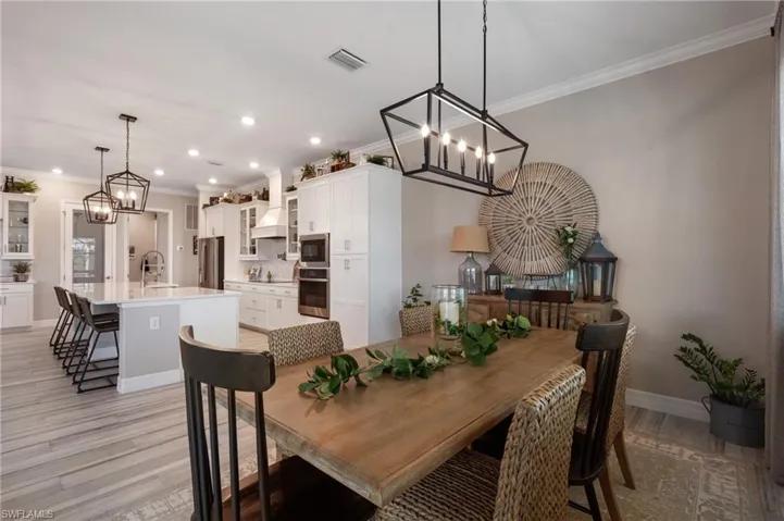 Dining space featuring crown molding, sink, and light hardwood / wood-style floors