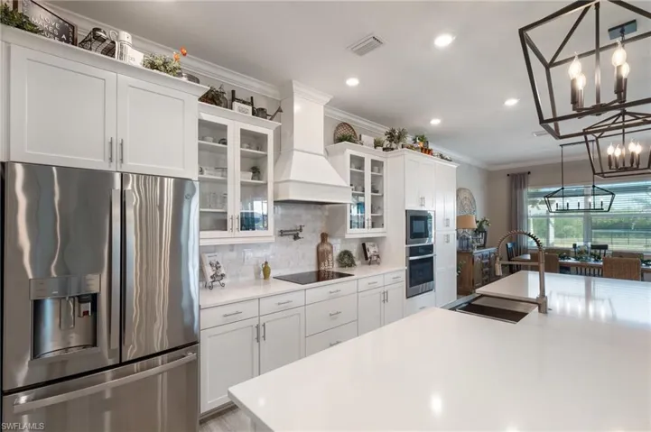 Kitchen featuring premium range hood, appliances with stainless steel finishes, and white cabinets