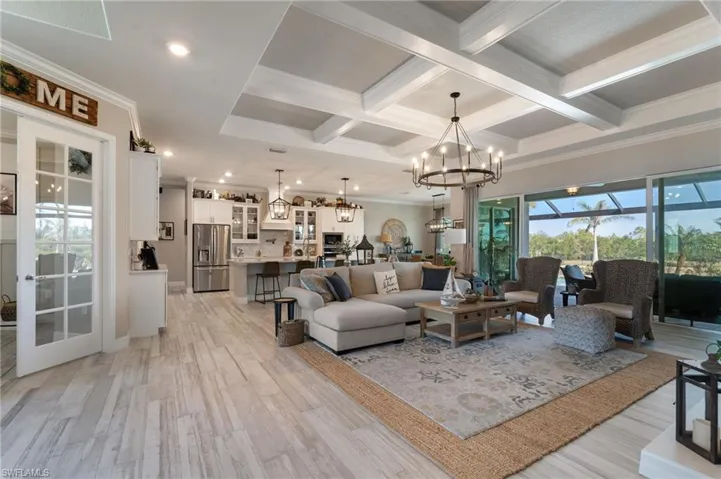 Living room featuring coffered ceiling, beam ceiling, and light hardwood / wood-style flooring